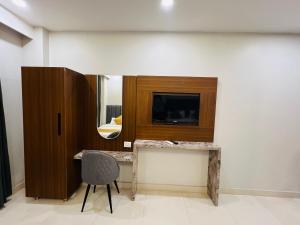 a room with a desk with a chair and a mirror at Hotel Royal Dot, Haridwar in Haridwār