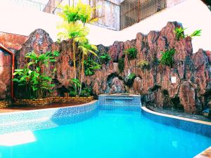 a swimming pool in a resort with a rock wall at Sentosa Lodge in Padang