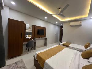 a hotel room with two beds and a television at Hotel Royal Dot, Haridwar in Haridwār