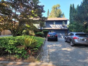 two cars parked in front of a house at A new luxury basement apartment in Surrey