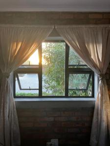 an open window with curtains in a room at Your home in the Cape in Cape Town