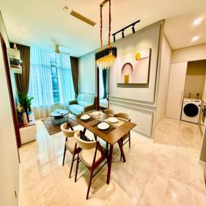 a living room with a table and chairs and a couch at Sky klcc by DMK luxury suites Apartment in Kuala Lumpur