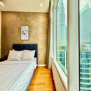 a bedroom with a bed and a large window at Sky klcc by DMK luxury suites Apartment in Kuala Lumpur