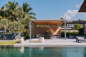a patio with a table and chairs next to a pool at Villa Essenza in Ban Han Pa To