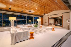 a living room with white furniture and a wooden ceiling at Villa Essenza in Ban Han Pa To
