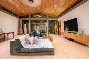 a living room with a couch and a flat screen tv at Villa Essenza in Ban Han Pa To