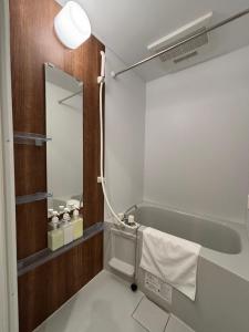 a bathroom with a bath tub and a mirror at Lion Heiwa Odori in Hiroshima +27 photos