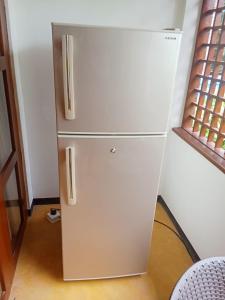 a white refrigerator in a kitchen next to a window at JAGA HOME in Tangalle