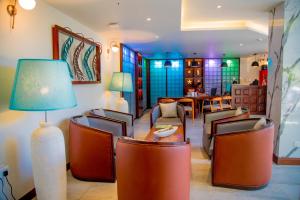 a living room with chairs and a table and a lamp at Lavendish Beach Resort in Unawatuna