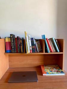 a book shelf with a bunch of books and a laptop at Fly-In Stay Katunayake in Katunayaka