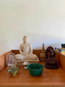 a desk with aitating buddha statue and other items on it at Fly-In Stay Katunayake in Katunayaka