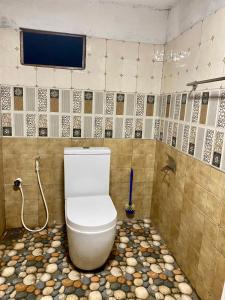 a bathroom with a toilet in a tiled room at Fly-In Stay Katunayake in Katunayaka