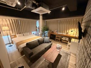 a bedroom with a bed and a couch and a table at TOKYO-W-INN Asakusa in Tokyo +76 photos