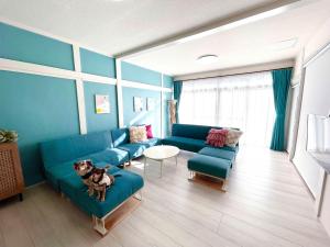 a living room with a couch and a dog sitting on a chair at KOKOYUI GUESTHOUSE Taiji in Taiji