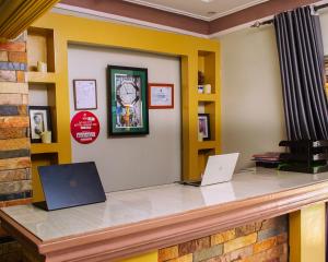 a reception counter with two laptops on it at Meltonia Luxury Inn in Busia