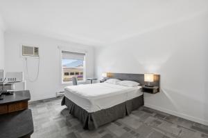a bedroom with a large bed and a window at Lillooet Hotel Victoria in Lillooet +16 photos