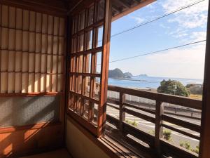 a room with a window looking out at the ocean at Tasogare in Kihokucho