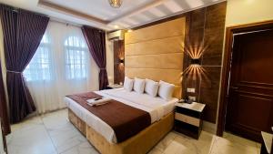 a bedroom with a large bed with a wooden headboard at Presken Hotel White House, Lekki, Lagos in Lagos +72 photos
