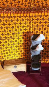 a room with a bed and a shelf with towels at Desert waves camp in Badīyah +47 photos