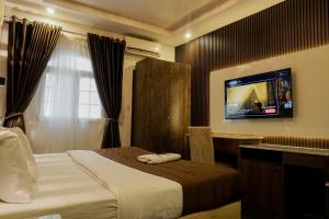 a hotel room with a bed and a flat screen tv at Presken Hotel White House, Lekki, Lagos in Lagos