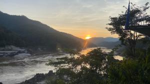 a view of a river with the sunset in the background at Mekong Backpackers in Pakbeng