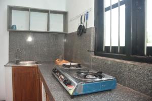 a kitchen with a stove top on a counter at Chenudi Villa Ahangama in Ahangama +37 photos
