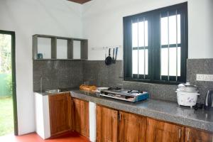 a kitchen with a counter top with a stove at Chenudi Villa Ahangama in Ahangama
