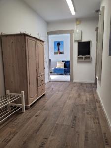 a living room with a large wooden cabinet and a tv at ZwischenWasser in Jübek +4 photos