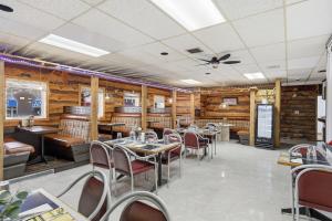 a restaurant with tables and chairs and wooden walls at Lillooet Hotel Victoria in Lillooet