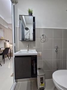 a bathroom with a sink and a mirror and a toilet at WeStay by KM Staycations in Dagupan