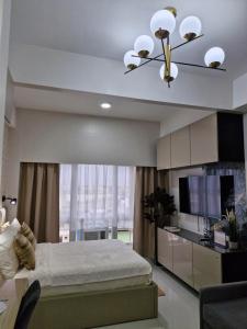 a bedroom with a bed and a ceiling fan at WeStay by KM Staycations in Dagupan +16 photos