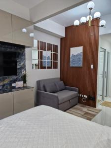 a bedroom with a bed and a couch and a television at WeStay by KM Staycations in Dagupan