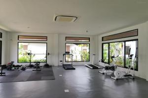 una palestra con diverse attrezzature per esercizi in una stanza con finestre di Lanna Deer Chiang Mai a Chiang Mai