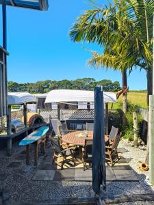 a patio with a table and chairs and a umbrella at Harbour Views House or Flat in Tahawai