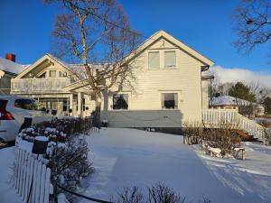 a white house with a snow covered driveway at Hammergaarden - Kårstua - Panoramic Arctic Stay in Sortland