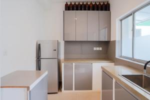 a kitchen with white cabinets and a refrigerator at Eklektik in Colombo +18 photos