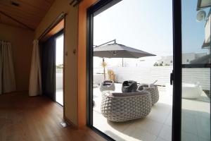 a room with a patio with an umbrella and chairs at Suma Beach House Ref in Takatorichō