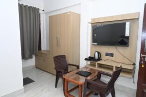 a living room with a table and a television at Prakriti Hill Resort in Nandaprayāg