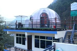 a building with an observatory on top of it at Prakriti Hill Resort in Nandaprayāg