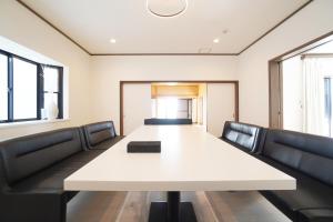 a conference room with a white table and black chairs at Suma Beach House Ref in Takatorichō