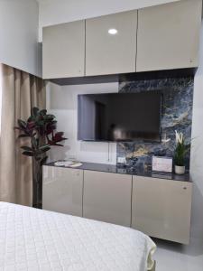 a bedroom with a bed and a flat screen tv at WeStay by KM Staycations in Dagupan