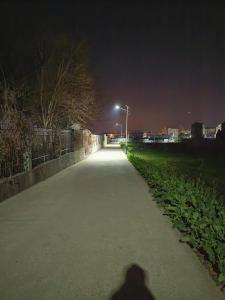a shadow of a person walking down a sidewalk at night at 天天绘住 in Xianzong +5 photos