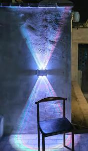a chair sitting in front of a wall with a light at 天天绘住 in Xianzong