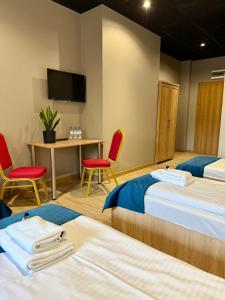 a hotel room with two beds and a table and chairs at Podhalanin noclegi in Wadowice