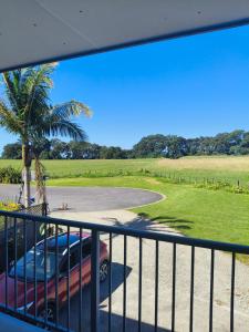 a man standing on a balcony looking at a car at Harbour Views House or Flat in Tahawai +13 photos