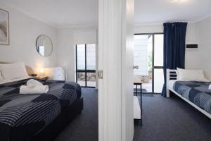 a hotel room with two beds and a balcony at Beachside Garden Apt Beach Scarborough with Parking in Perth +64 photos