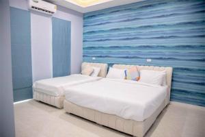 a bedroom with two beds with a painting on the wall at Chern Mar Pool Villa Cha-am in Cha Am