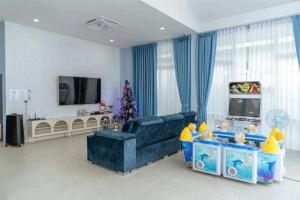 a living room with a christmas tree and a blue couch at Chern Mar Pool Villa Cha-am in Cha Am