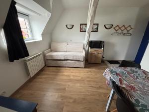 a living room with a couch and a table at Appartement piscine cure thermale in La Roche-Posay