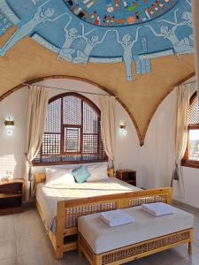 a bedroom with two beds and a painting on the ceiling at Thebes Hotel in Luxor